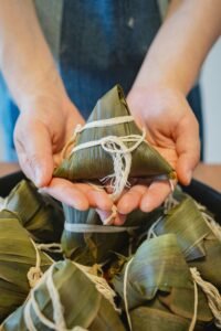 Close-up of homemade Japanese rice dumpling wrapped in bamboo leaf, showcasing detailed craftsmanship.