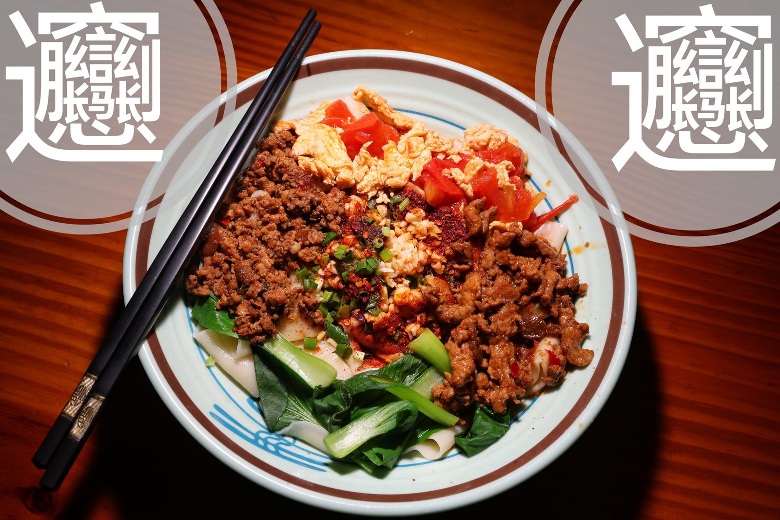 A bowl of biangbiang noodles with meat, vegetables, and chili